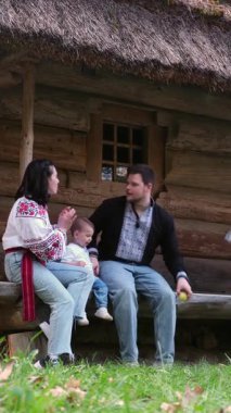 Kırsal kesimdeki ahşap kulübe dışında çocuklu bir aile.