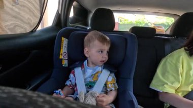 Anne ve oğlu arabanın arka koltuğunda güvenle oturuyorlar..