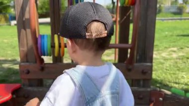 Dışarıdaki oyun parkında renkli boncuklarla oynayan çocuk..