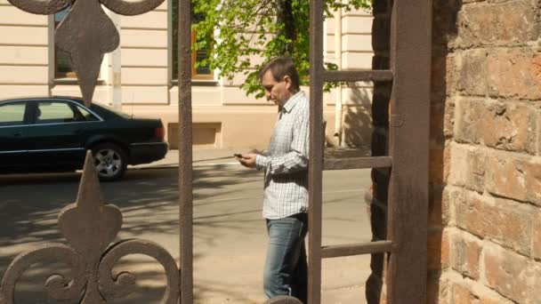 Мужская переписка со смартфоном в городе — стоковое видео