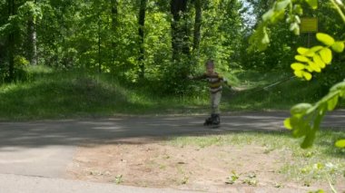 Küçük çocuk tekerlekli paten parkta rides