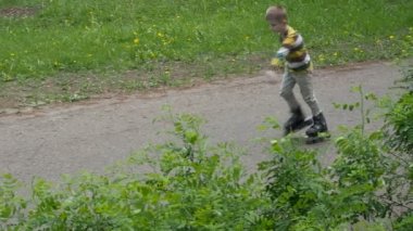 Küçük çocuk tekerlekli paten parkta rides