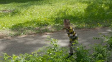 Küçük çocuk tekerlekli paten parkta rides