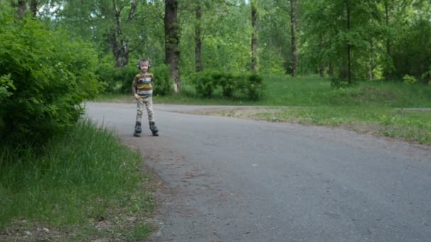 Bambino cavalca sui pattini a rotelle nel parco — Video Stock