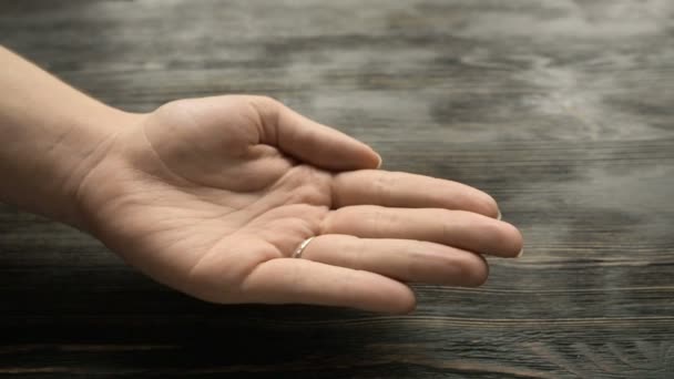 Nahaufnahme einer Frau, die sich Tabletten in die Hand schüttet — Stockvideo