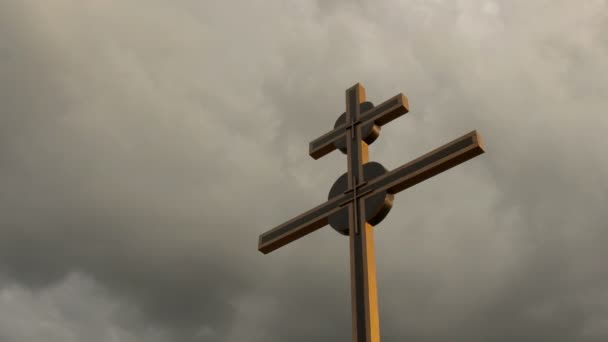 Large cross silhouetted against storm clouds at sunset — Stock Video