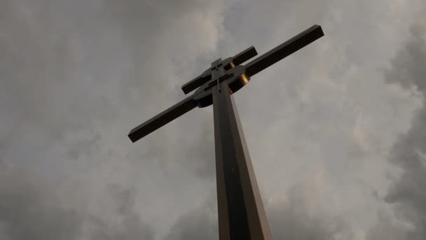 Groot kruis afsteekt tegen de storm wolken bij zonsondergang. — Stockvideo