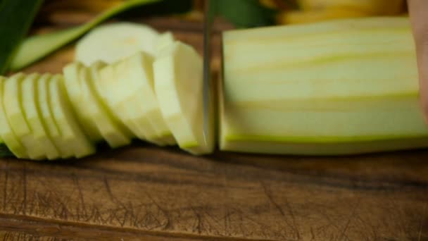 Skivad zucchini i cirklar på träbord — Stockvideo