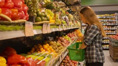 Güzel ve genç birbayan meyve ürünlerinin bir süpermarkette alışveriş