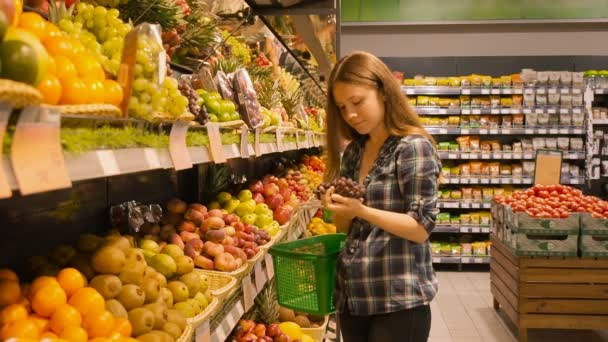 Vacker ung kvinna shopping för frukter produkter på en stormarknad — Stockvideo