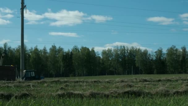Сельскохозяйственный трактор собирает солому в поле Стоковое Видео