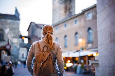 İtalya 'da tatil sırasında gün batımında Bergamo sokaklarını keşfeden yalnız bir gezgin. Akşam Citta Alta, Bergamo, İtalya 'daki Piazza Vecchia şehir meydanında