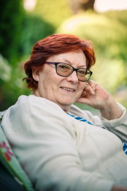 Gülümseyen, gözlüklü, kızıl saçlı, bahçede oturan ve emekliliğinin ve altın yıllarının tadını çıkaran son sınıf öğrencisi. Samimi bir portre