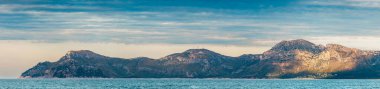 Alcudia Körfezi kıyısı. Can Picafort 'tan panoramik manzara. İspanya, Mallorca 'da deniz, gökyüzü ve dağ sıraları