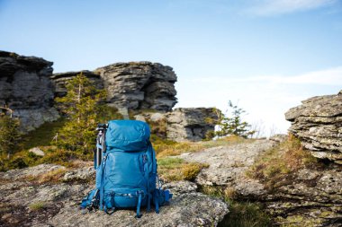Dağlarda yürüyüş yaparken kayaların üzerinde tripodla yürüyüş yapmak. Yürüyüş ve seyahat ekipmanları