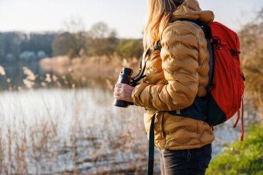 Kuş izleme ve gölde vahşi hayvan gözlemleme. Kadın dürbünle kuşları izliyor.