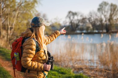 Dürbünlü bir kuş bilimci gölde su kuşlarını arıyor. Doğal ortamında kuş izleme