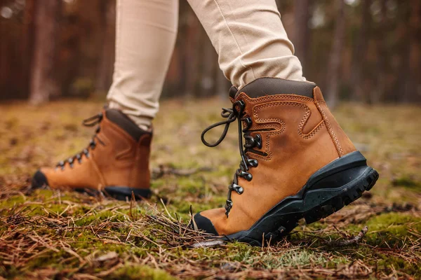 Yürüyüş botu. Deri bacaklı, su geçirmez bilekli botlar ormanda yürüyor.