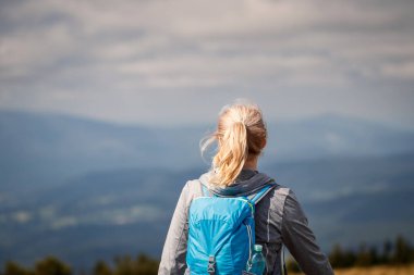 Sırt çantalı bir kadının dağlarda yürüyüşü. Doğadaki macera
