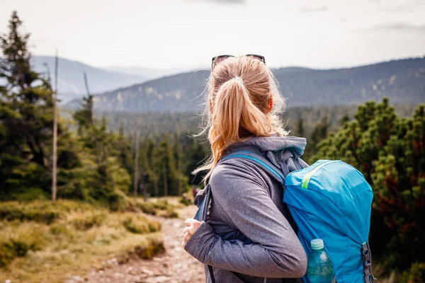 Dağ yürüyüşü. Turistler doğanın manzarasının tadını çıkarıyorlar. Sırt çantalı bir kadın sıradağlara bakıyor. Aktif yaşam tarzı ve macera konseptiyle seyahat et
