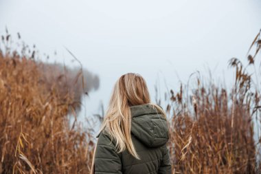 Sisli bir gölün kenarında yalnız üzgün bir kadın duruyor. Depresyon ve endişe durumları