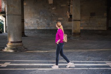 İtalya 'nın Bergamo, Citta Alta kentindeki Piazza Duomo şehir meydanında yürüyen kadın turist. Avrupa 'da şehir tatili