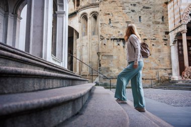 Avrupa 'da tek başına seyahat ederken tarihi Bergamo, İtalya' yı keşfeden kadın turist. Katedral di Sant 'Alessandro Martire giden taş merdivenler.
