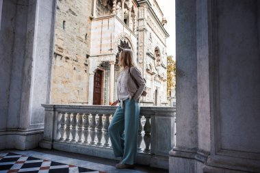 İtalya, Citta Alta Bergamo 'da Santa Maria Maggiore Bazilikası' nın ortaçağ mimarisini keşfeden bir kadın turist. Avrupa 'da şehir arası