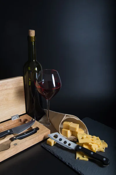 Bottiglia di vino con bicchiere, formaggio e coltello da formaggio — Foto Stock