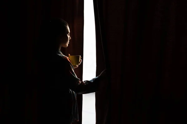 Junge Frau Trinkt Morgenkaffee Blick Fenster Durch Vorhänge Kopieren Raum — Stockfoto