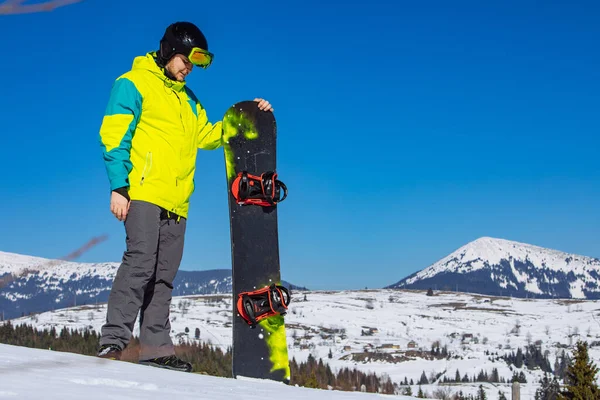 Homme en lunettes de soleil tenant snowboard — Photo