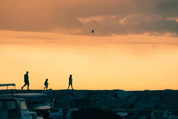 Πατέρας με τα κορίτσια κόρη περπάτημα με πέτρινο δρόμο στο ηλιοβασίλεμα. — Φωτογραφία Αρχείου