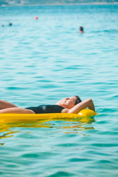Güzel Seksi Kadın Deniz Suyunda Sarı Şişme Yatakta Güneşleniyor — Stok fotoğraf