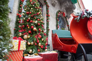 Kafe restoranının Noel süslemesi köknar ağacı altında kırmızı sarı oyuncaklar hediye kutuları var.