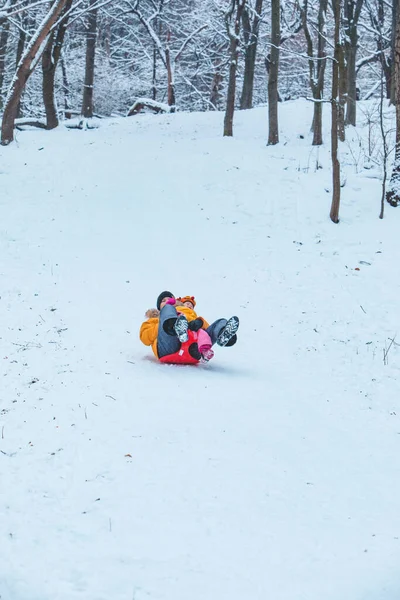 Vater Mit Tochter Gelben Wintermänteln Rutscht Verschneiten Hügel Familienzeit — Stockfoto