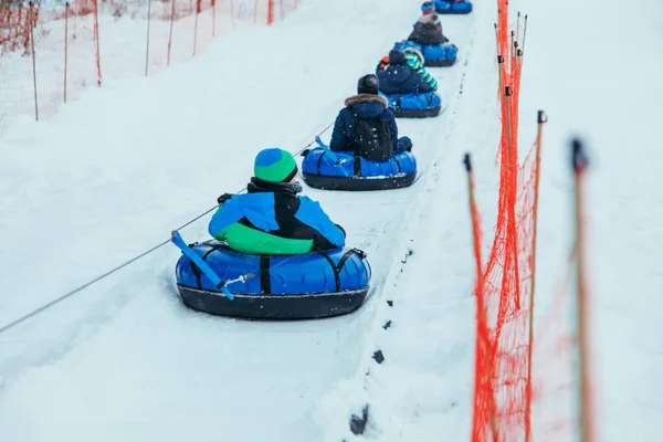 line for snow tubing. pull people up to hill. winter activities