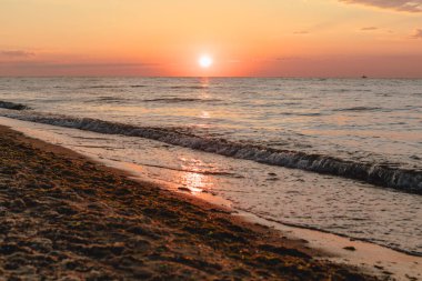 Kumlu deniz sahilinin üzerinde gün doğumunun manzarası. Boşluğu kopyala