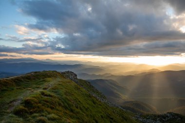 Dağların tepesindeki günbatımının manzarası. Boşluğu kopyala