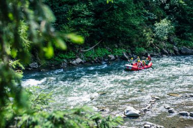 Dzembronia, Ukrayna - 1 Ağustos 2020: dağ nehri kıyısında rafting yapan bir grup insan. Boşluğu kopyala.