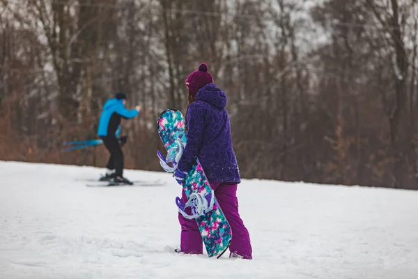 Frau Läuft Mit Snowboard Lila Mantel Bergauf — Stockfoto