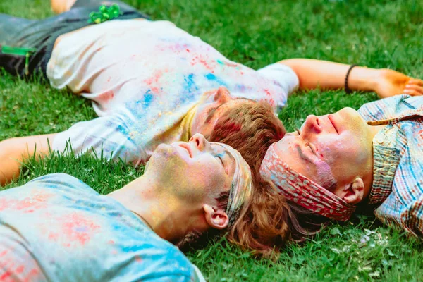 Amigos Felices Acostados Suelo Hierba Verde Sucio Pinturas Holi Vacaciones — Foto de Stock