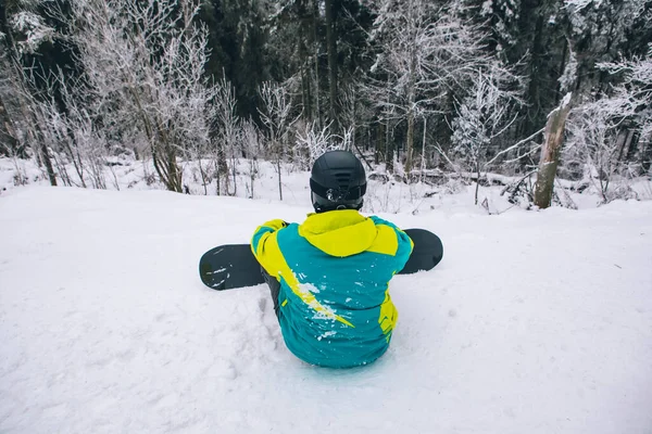 Man Sitter Toppen Kullen Med Snowboard Tittar Kulle Med Skogen — Stockfoto