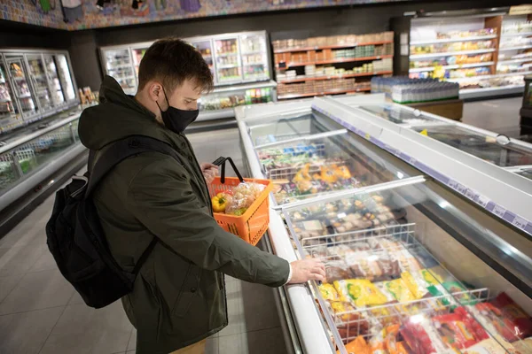 man choosing product in store fridge