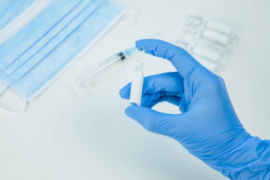 Tıbbi eldivenleri verin. Aşıyla ampulü yakın tutun.