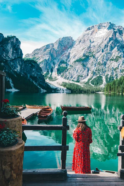 山の湖を見て桟橋で赤いドレスの女性 夏休み — ストック写真