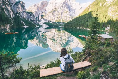 Kürsüde oturan kadın Kuzey İtalya 'da Pragser Wildsee' ye bakıyor. kopyalama alanı. yaz tatili