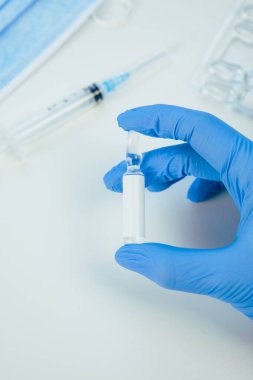 Tıbbi eldivenleri verin. Aşıyla ampulü yakın tutun.