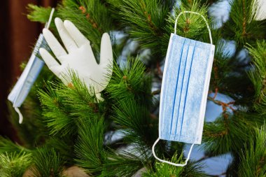 2021 yılbaşı konsepti eldivenler ve tıbbi maskeyle süslenmiş Noel ağacı