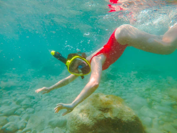 シュノーケリングマスクとフリッパーで水中の赤い水着の女性夏休み — ストック写真