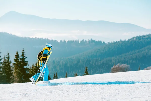 女性は冬の斜面の山を背景にスキーをし — ストック写真